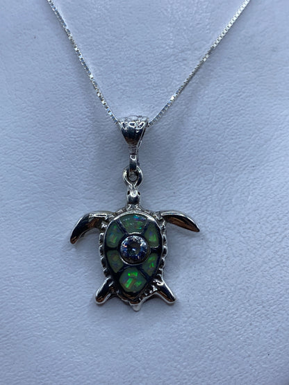 Dije de tortuga marina en plata .925 con ópalo de fuego multicolor colgando de cadena