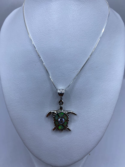 Detalle de la incrustación de piedra y las patas de la tortuga en plata