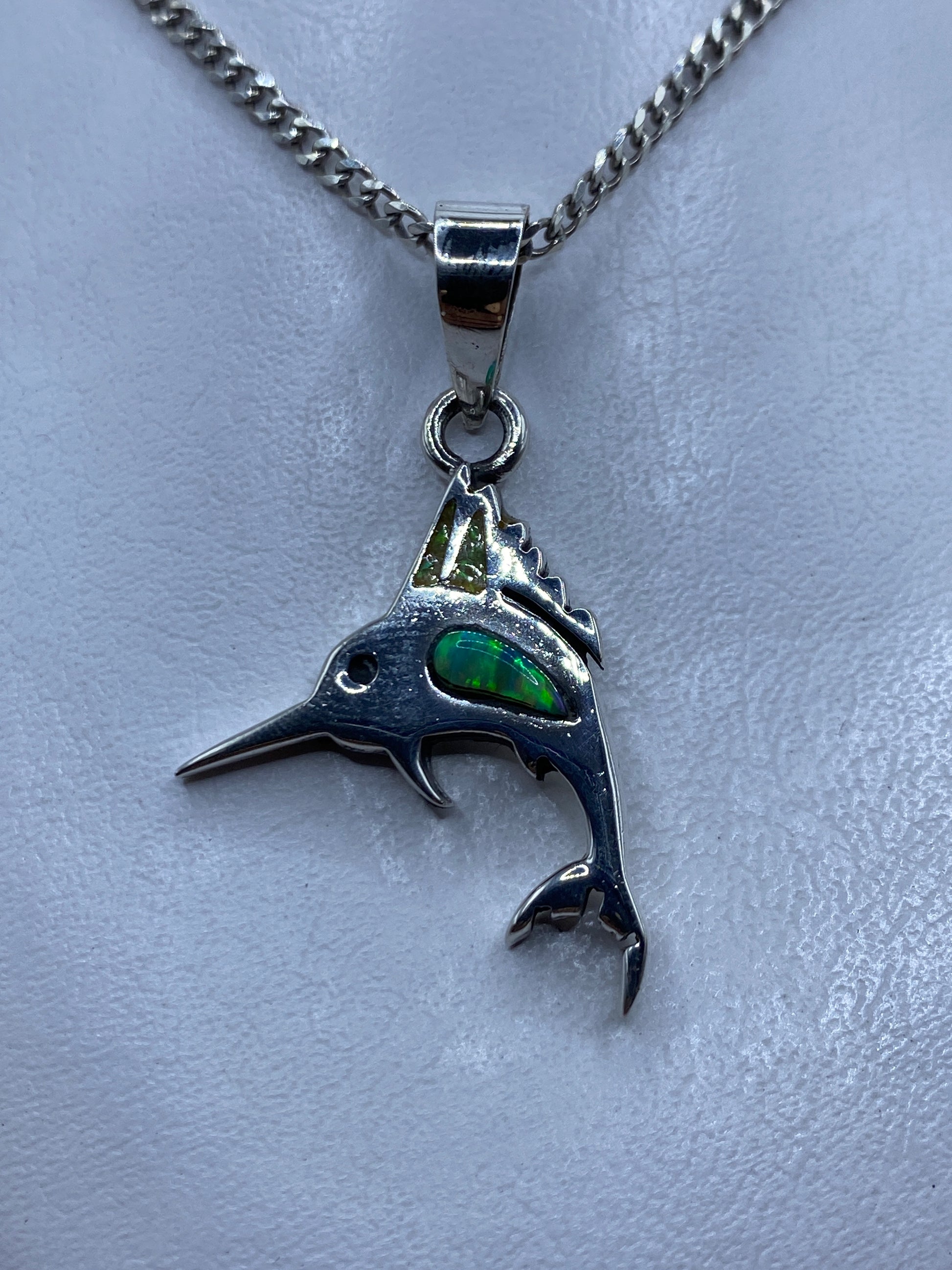 Dije de pez espada en plata .925 con ópalo de fuego verde en el ojo, colgado de cadena plateada