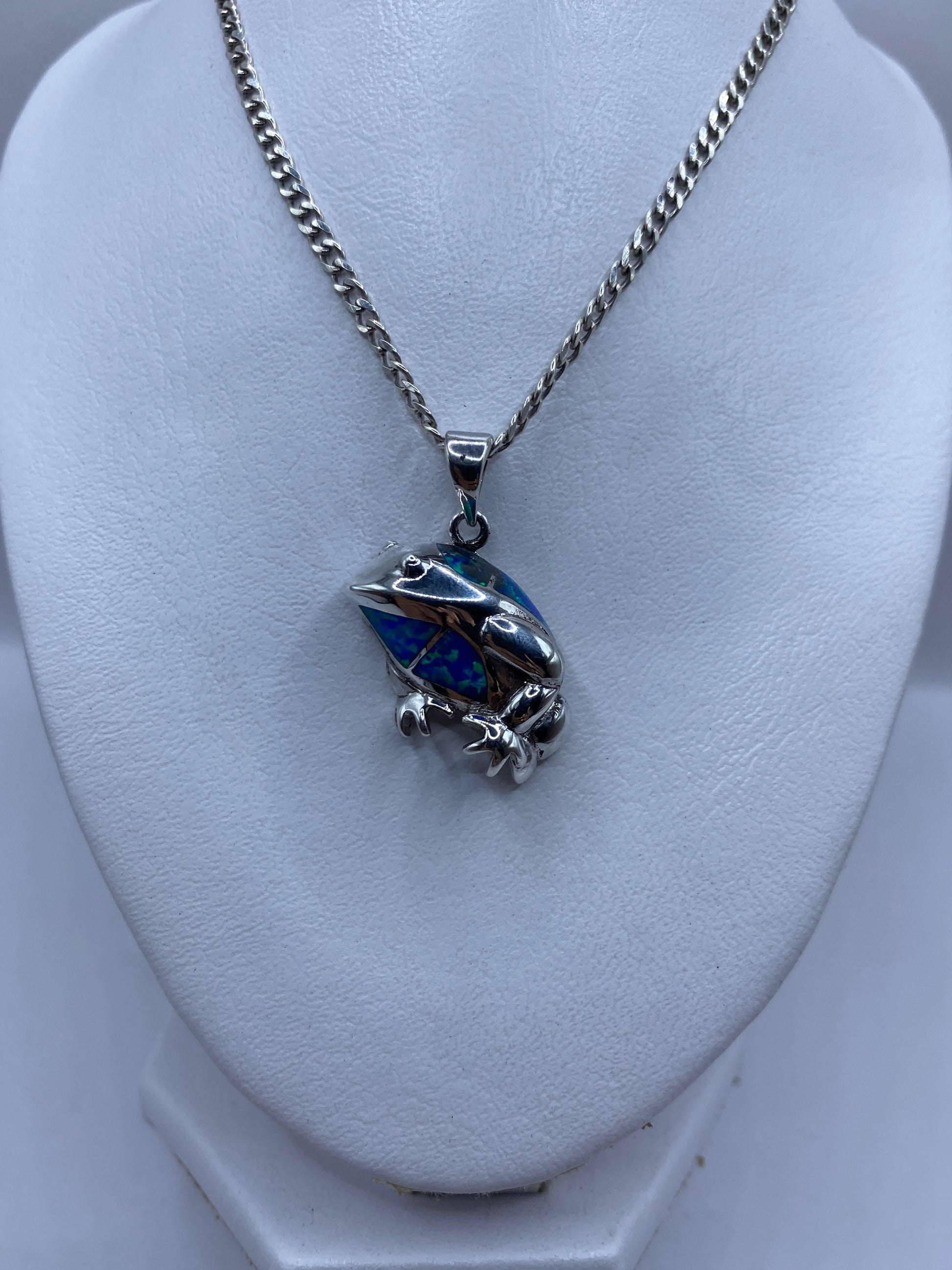 Detalle del ópalo de fuego azul engastado a mano en plata, mostrando reflejos verdes