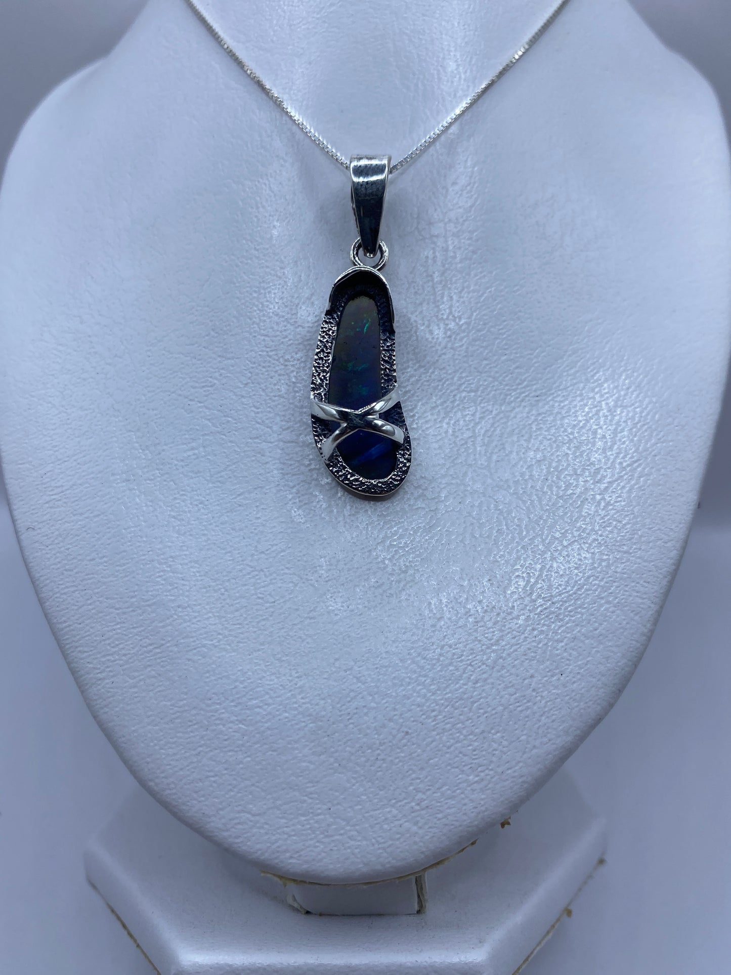 Detalle del ópalo de fuego en tonos azul profundo en el dije de plata