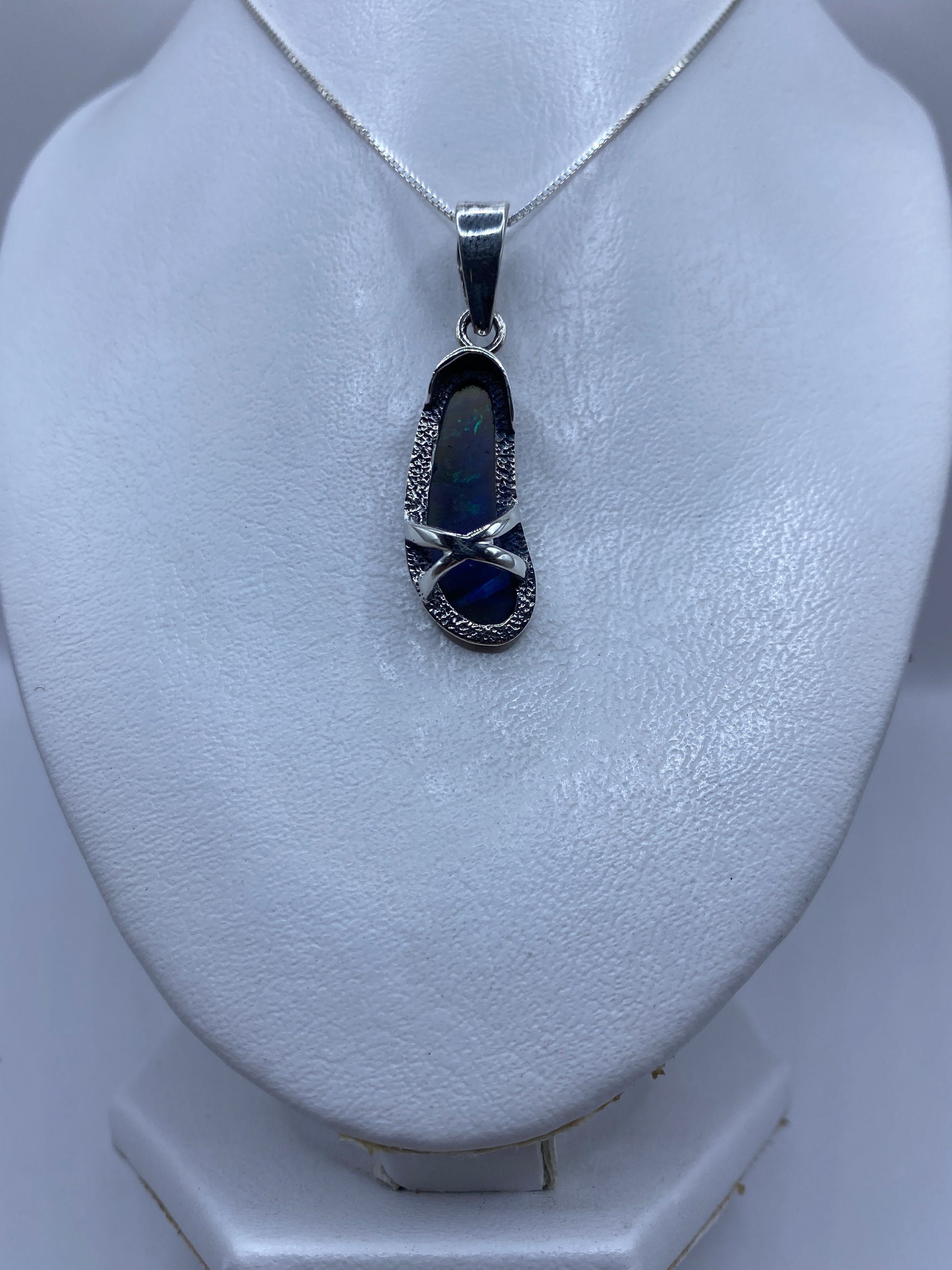 Detalle del ópalo de fuego en tonos azul profundo en el dije de plata