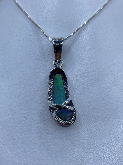 Dije de plata con ópalo de fuego azul cielo engastado, colgando de una cadena plateada