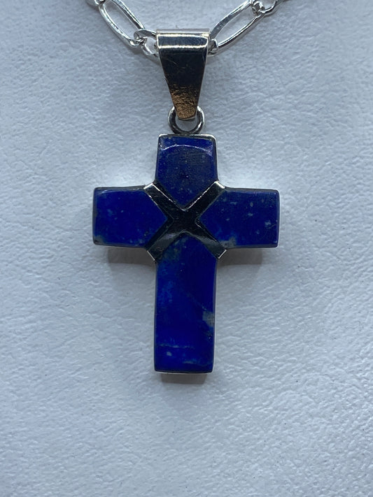 Dije cruz de plata .950 con lapislázuli azul profundo engastado, colgando de cadena plateada