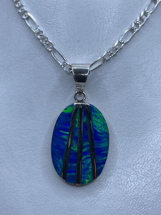 Dije de plata ópalo de fuego azul con incrustación de piedra, colgando de cadena figaro