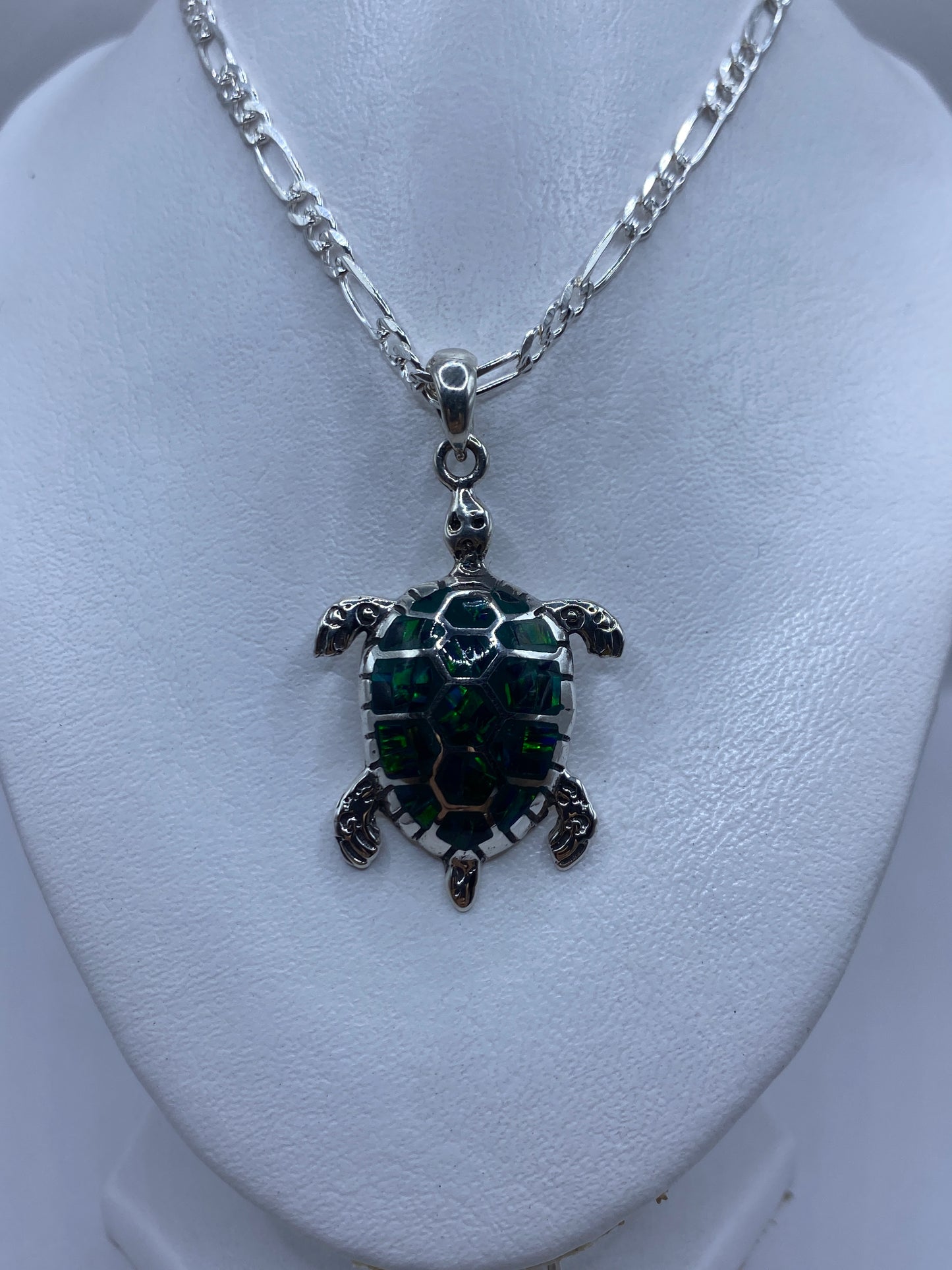 Medida del dije tortuga junto a regla, mostrando 5.2 cm de largo