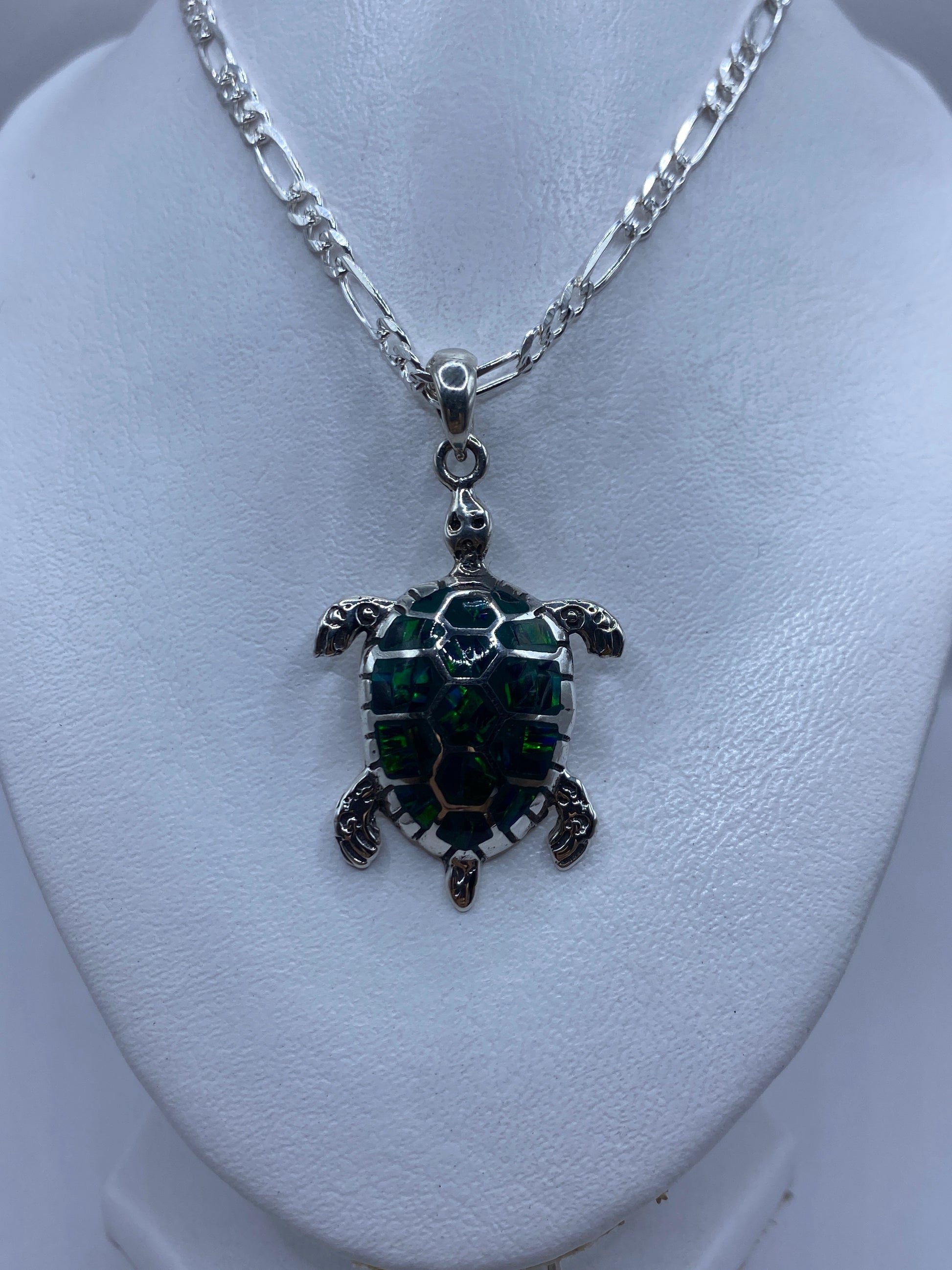Medida del dije tortuga junto a regla, mostrando 5.2 cm de largo