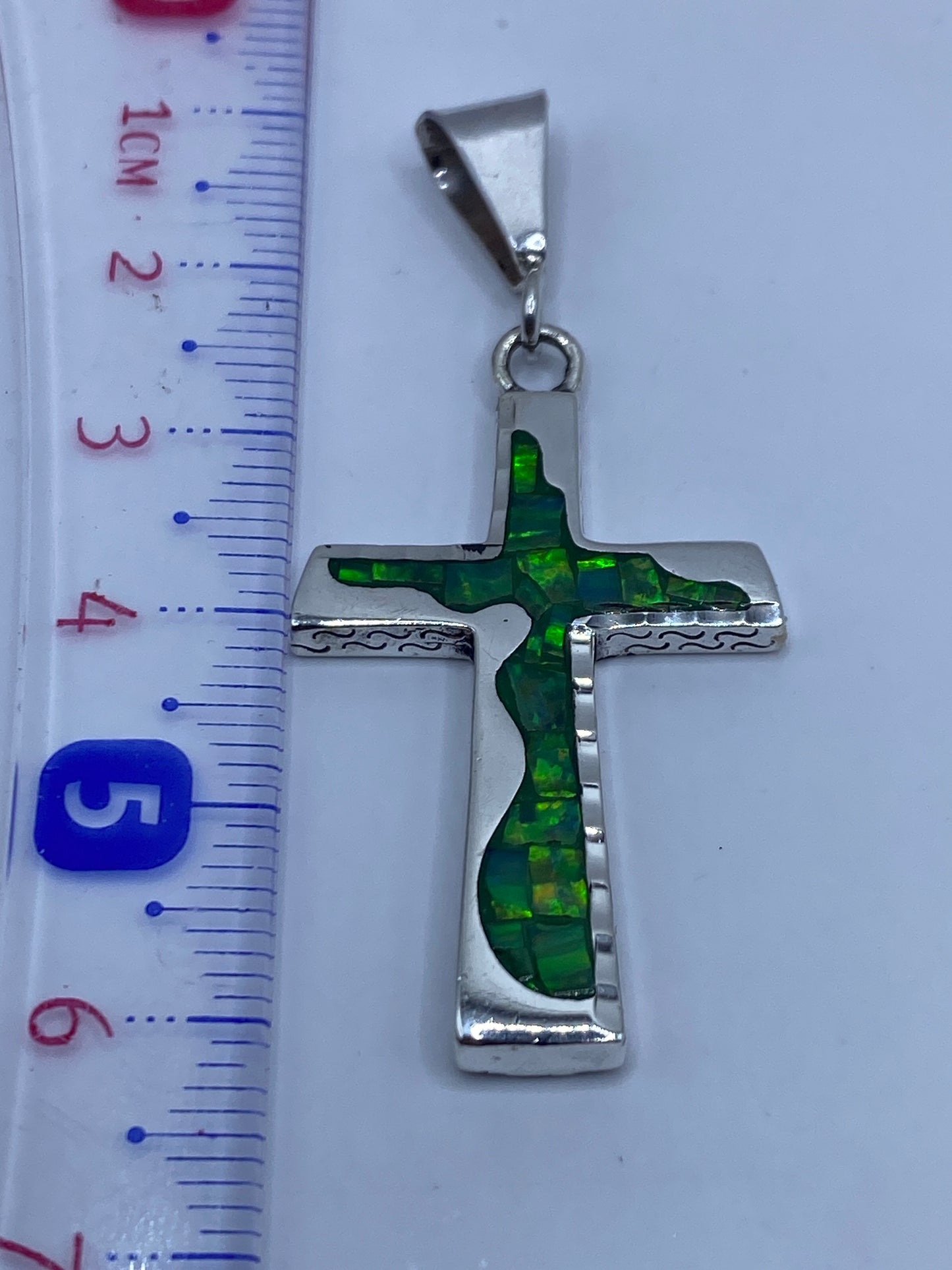 Dije de plata .950 sobre regla, midiendo 6 cm de largo, con peso de 5.3 gramos