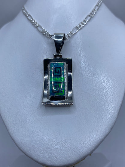 Detalle lateral del dije de plata sólida con el ópalo de fuego brillando