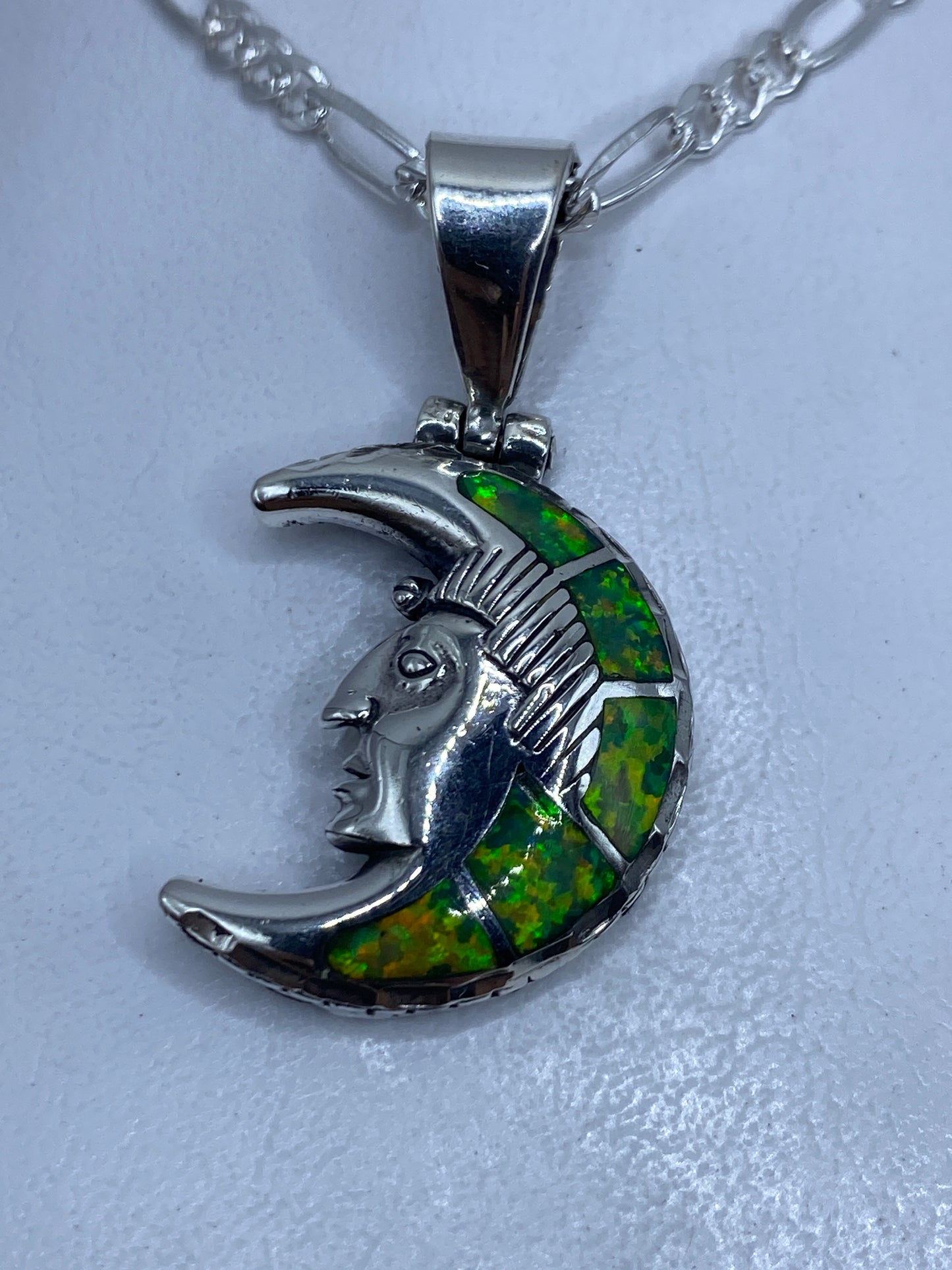 Dije de plata .950 con diseño lunar prehispánico y ópalo de fuego verde limón, visto de frente