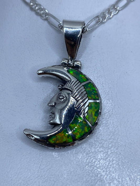 Dije de plata .950 con diseño lunar prehispánico y ópalo de fuego verde limón, visto de frente