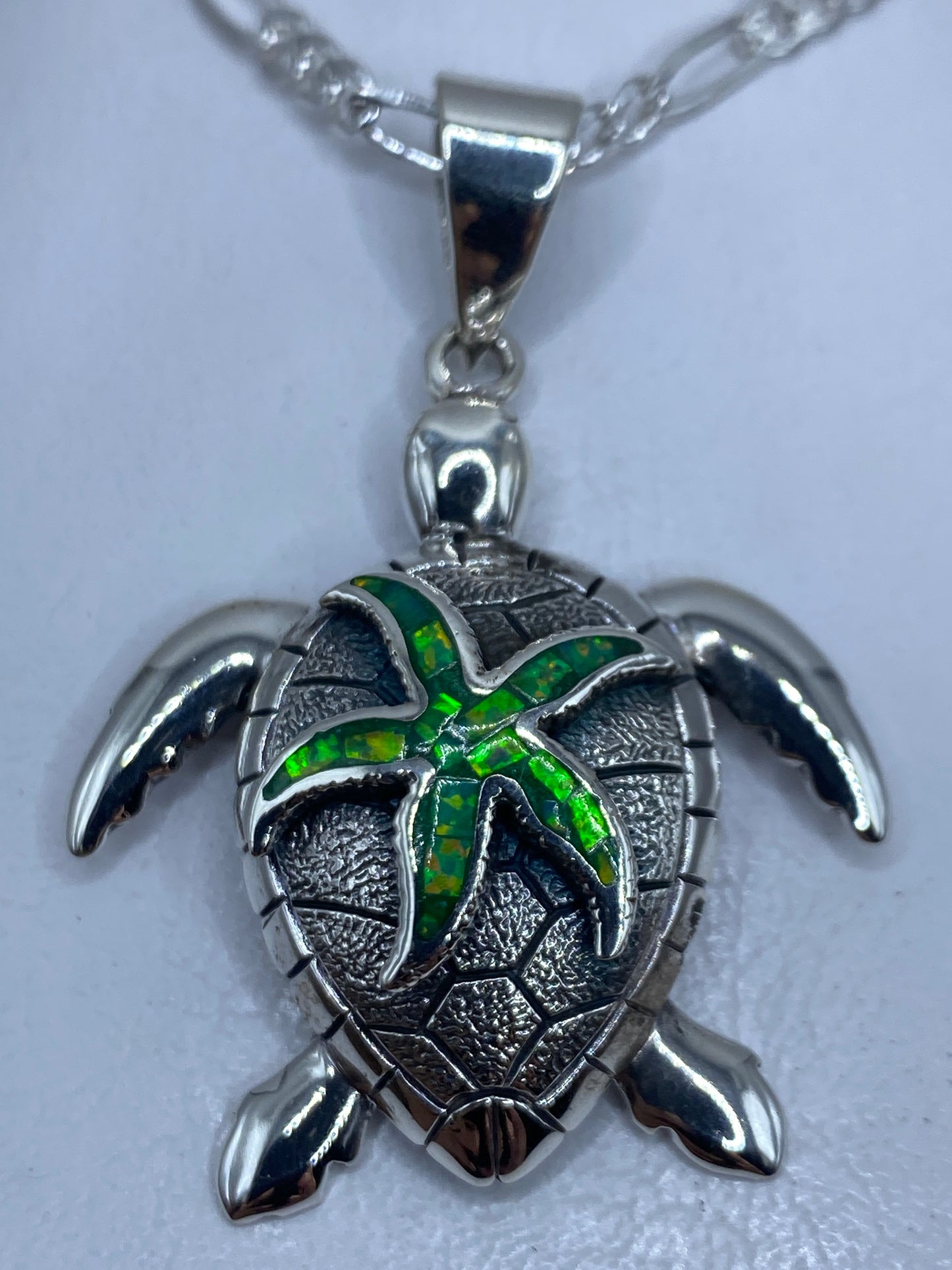 Dije tortuga marina de plata .950 con ópalo de fuego verde, visto de frente