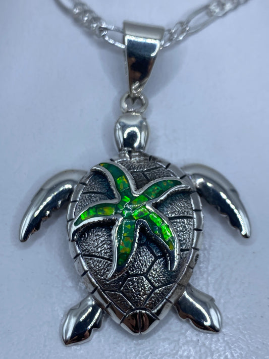 Dije tortuga marina de plata .950 con ópalo de fuego verde, visto de frente