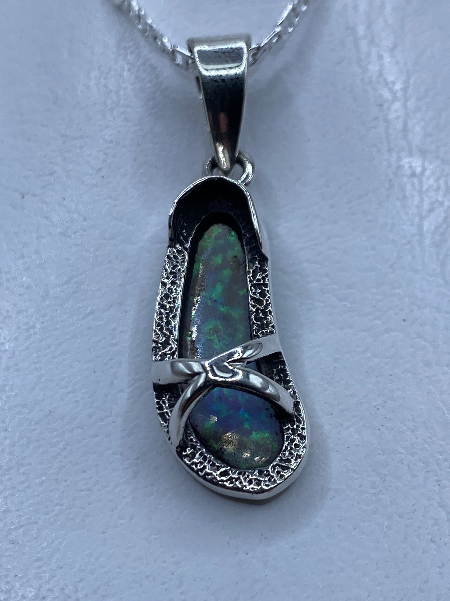 Dije de ópalo de fuego azul cielo engastado en plata .950, colgado en cadena de plata