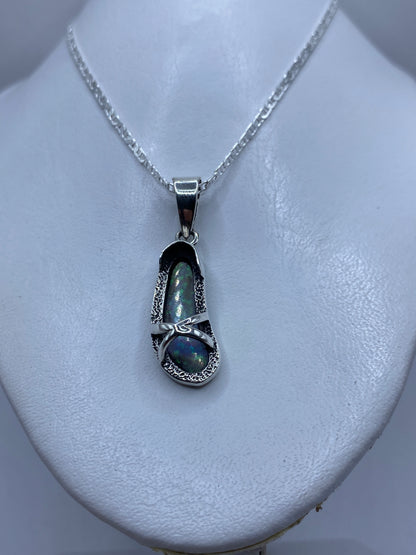 Detalle del ópalo de fuego con tonos azul y verde en engaste de plata manual