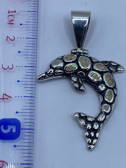 Dije delfín de Taxco pesando 5.5 gramos en báscula, mostrando tamaño real de 5.5 cm