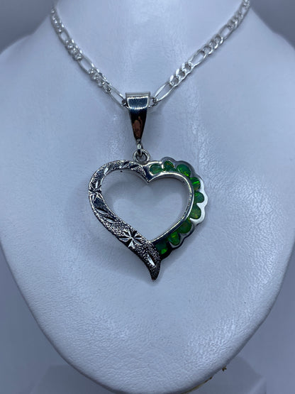 Detalle de la incrustación de ópalo de fuego con tonalidad verde luminosa en el dije corazón