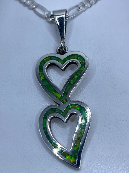 Dije de plata .950 con dos corazones apilados y Opalo de Fuego verde limón engastado