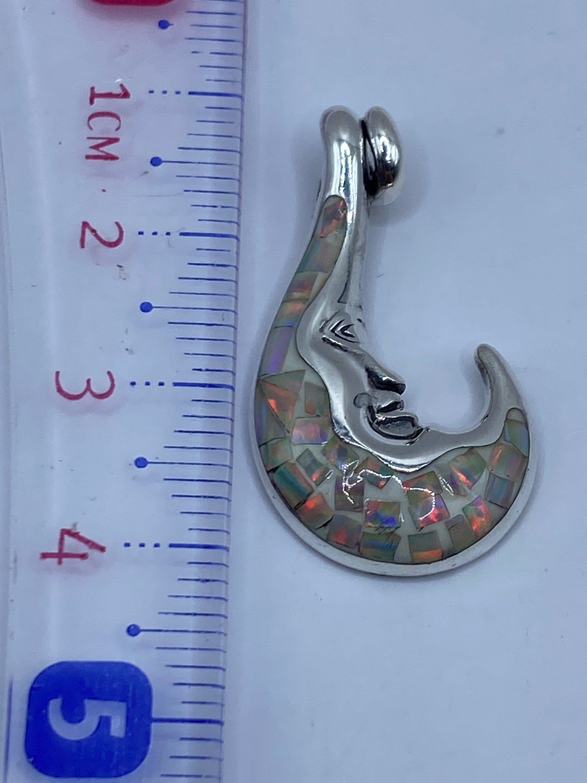 Dije de 3.8 cm junto a regla de centímetros para escala de tamaño