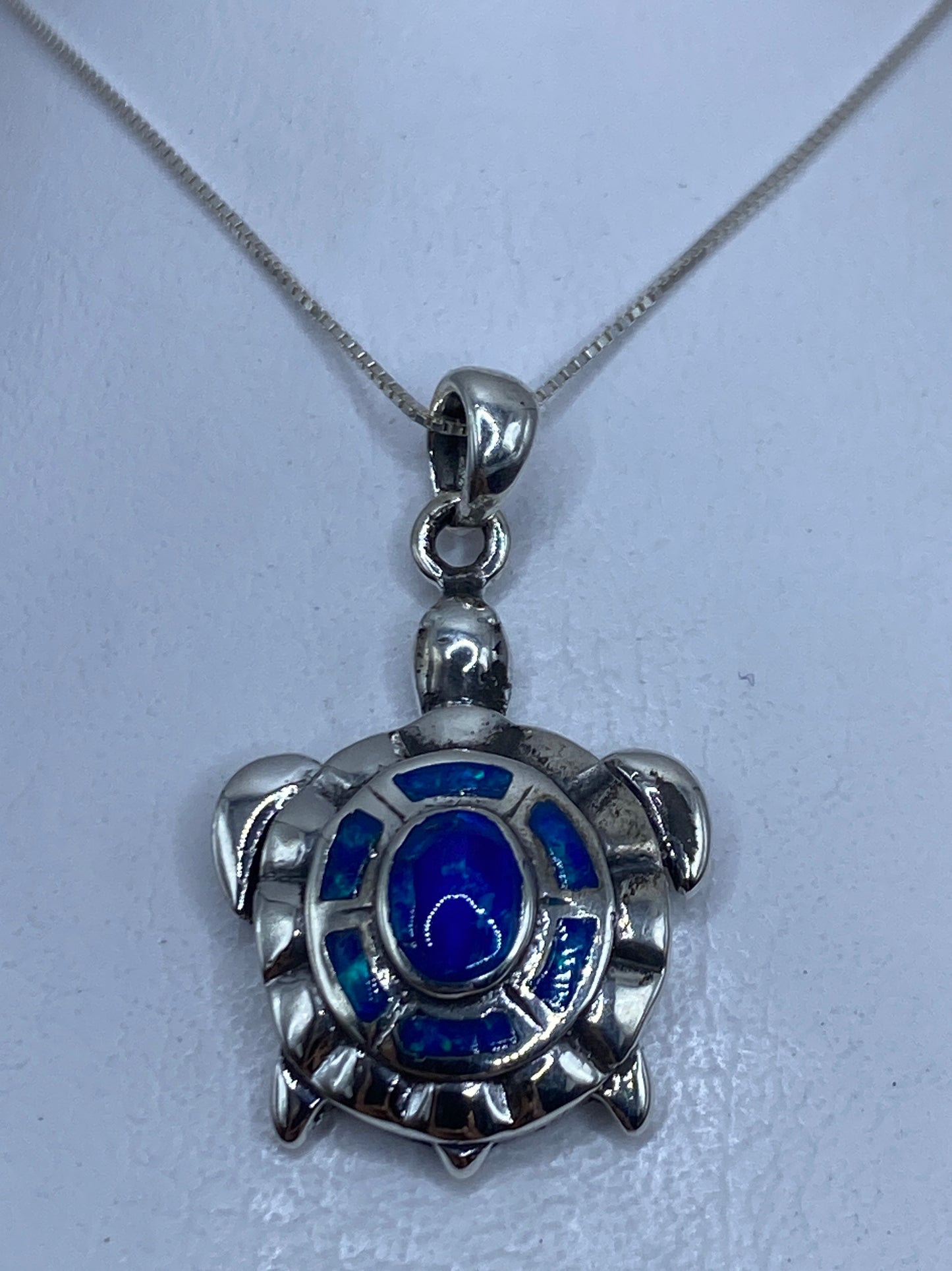 Dije tortuga de plata .950 con ópalo de fuego azul colgado en cadena plateada