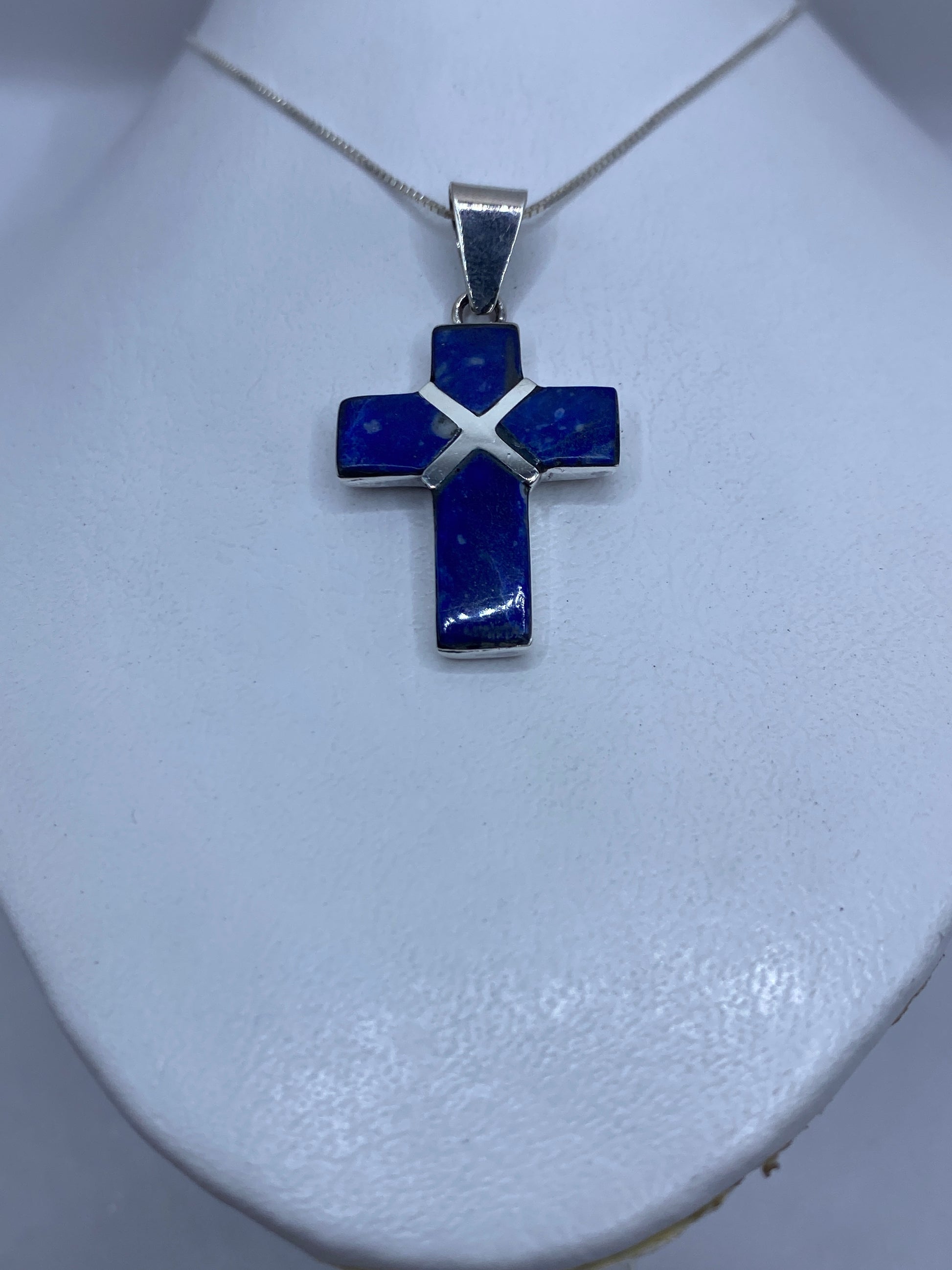 Detalle del engaste a mano del lapislázuli en la cruz de plata