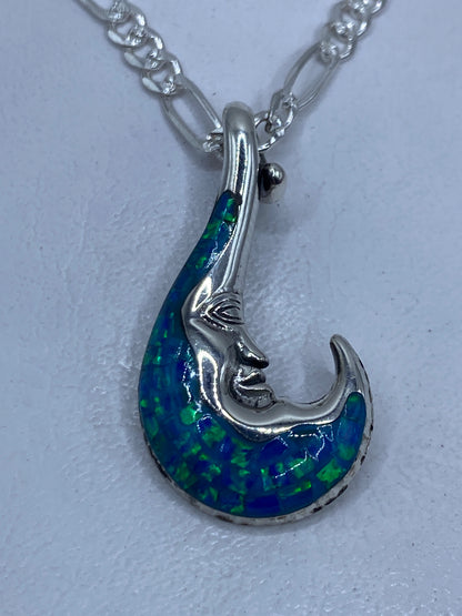 Dije luna de plata .950 con ópalo de fuego azul cielo, rostro grabado, colgante en cadena plateada