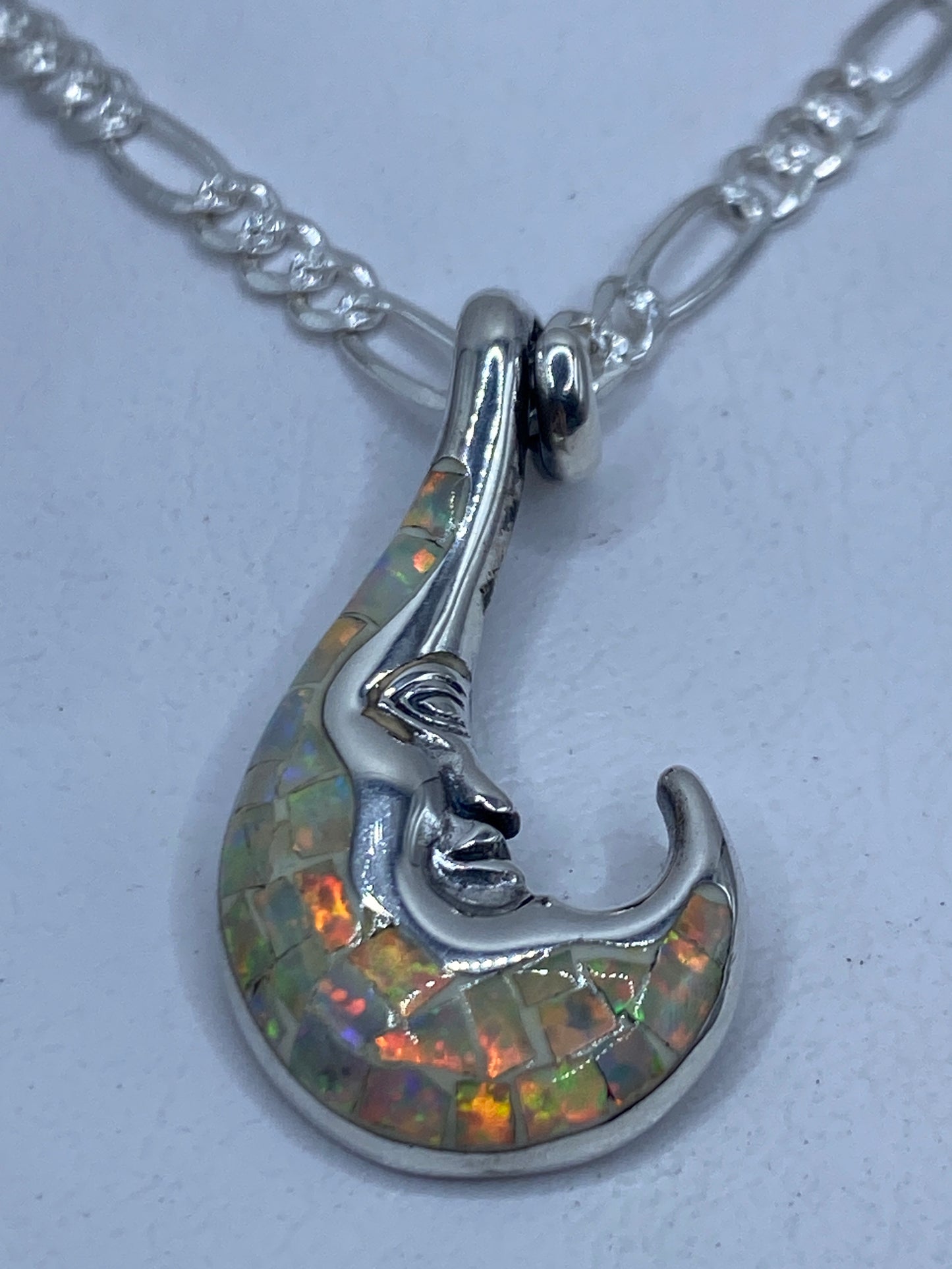 Dije de plata .950 con ópalo de fuego en forma de rostro escultural colgado en cadena figaro