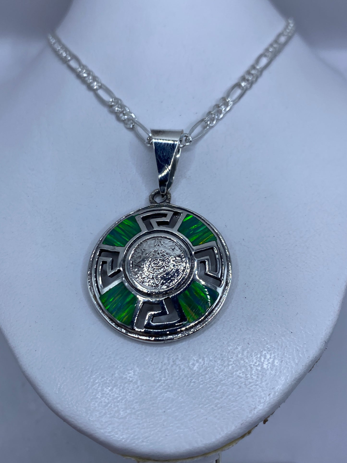 Dije de plata prehispánico sobre cadena en cuello, mostrando el tamaño de 5.3 cm
