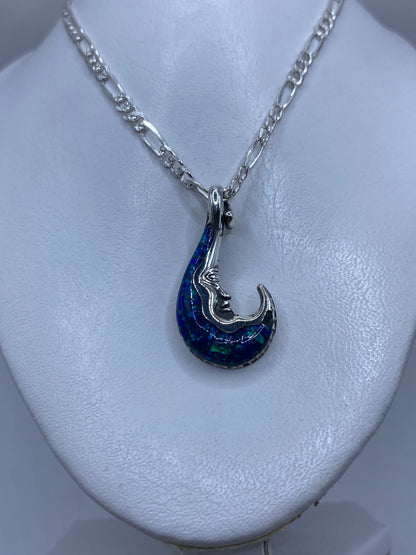 Detalle frontal del dije mostrando el ópalo de fuego con tonos azul verdoso