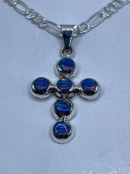 Cruz de plata .950 con ópalo de fuego azul sobre cadena plateada, vista frontal