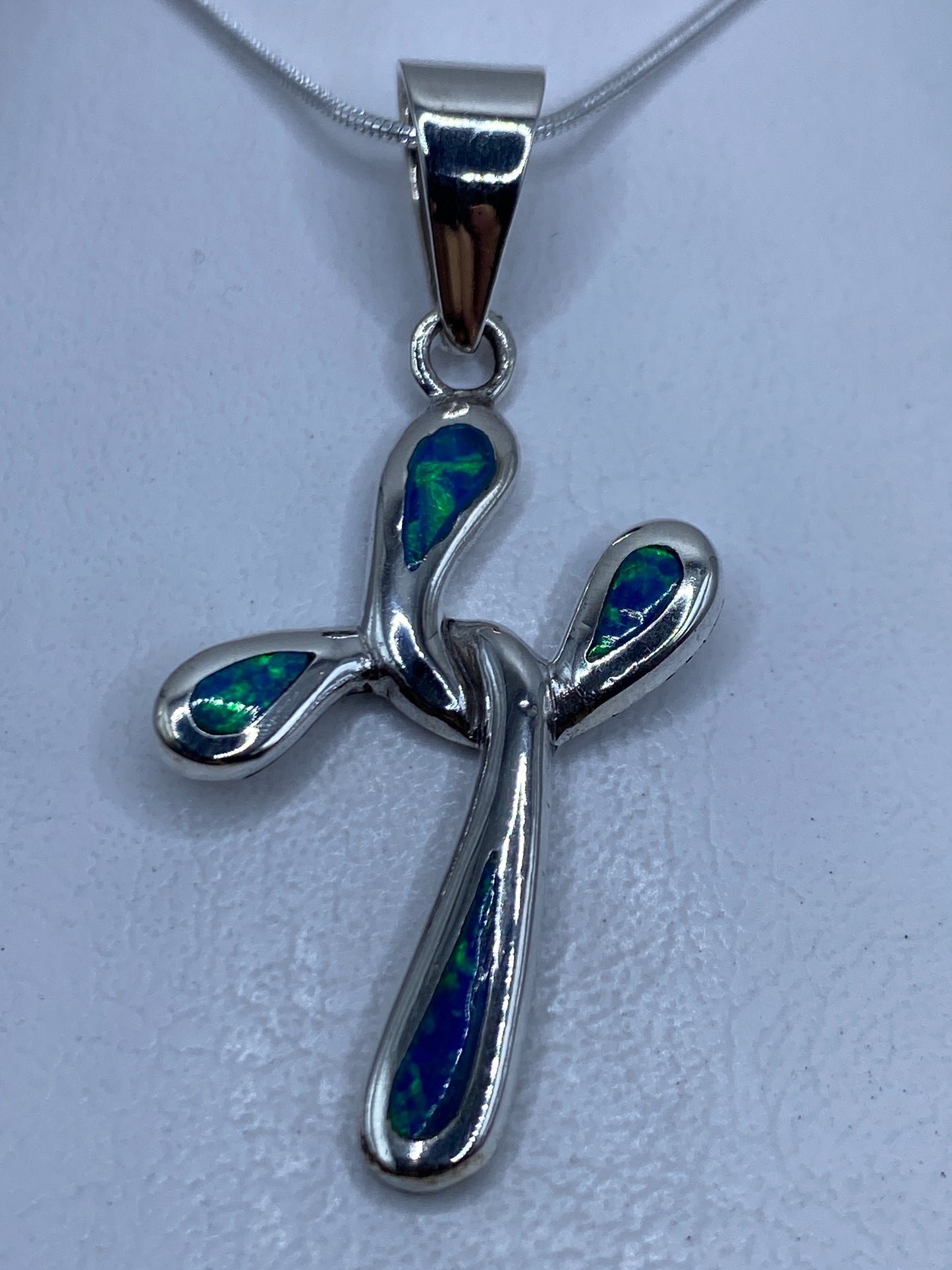 Dije cruz de plata .950 con opalo de fuego azul, sobre cadena de plata