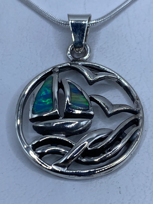 Dije de plata .925 con velero en relieve y ópalo de fuego azul cielo en el colgante