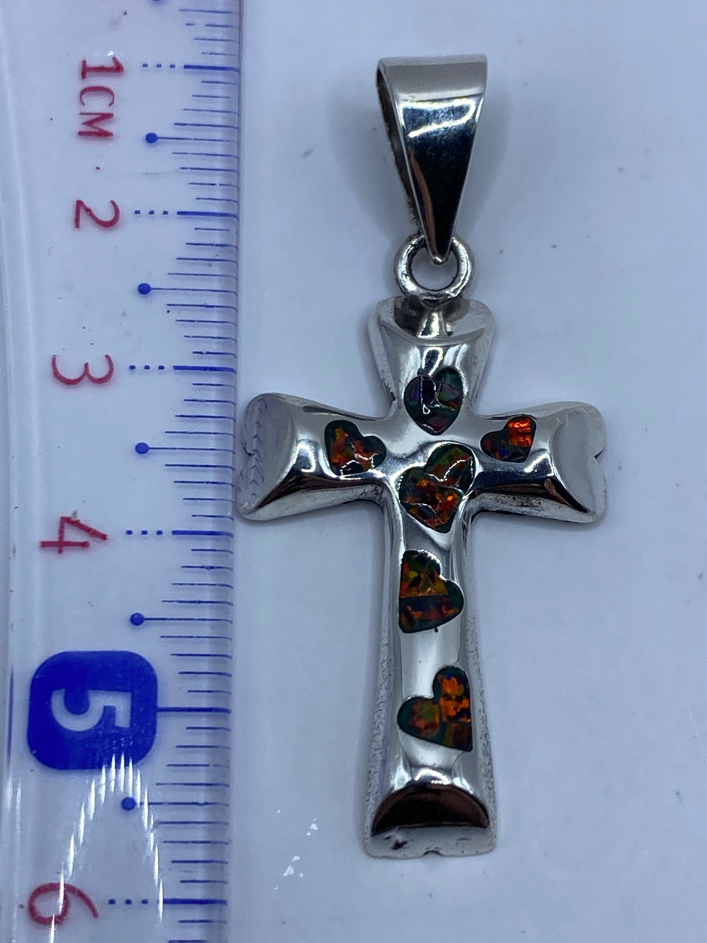 Medición de la cruz en regla: 5.6 cm de largo, dije sin cadena