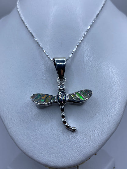 Detalle del ópalo de fuego engastado en las alas de la libélula, tonos verdes y azules