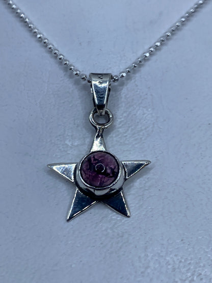 Dije de estrella de plata .925 con piedra morada engastada en el centro
