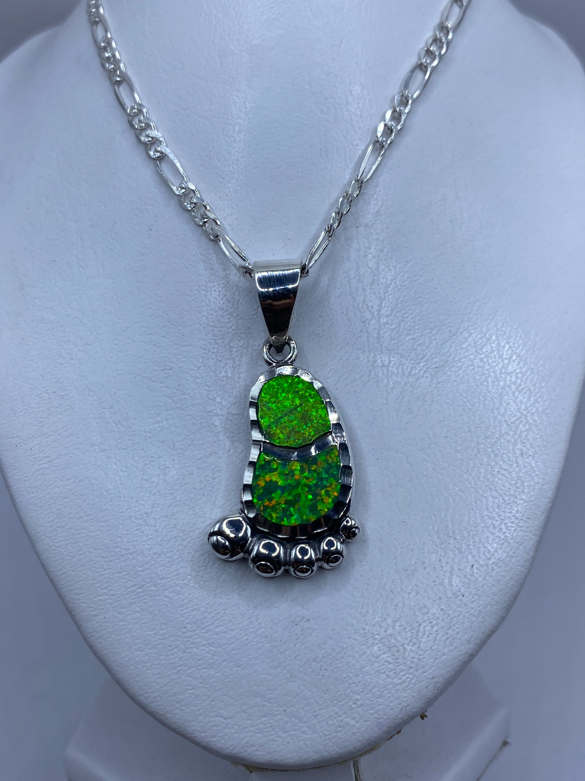 Detalle del engaste a mano del ópalo de fuego verde limón en la plata .950