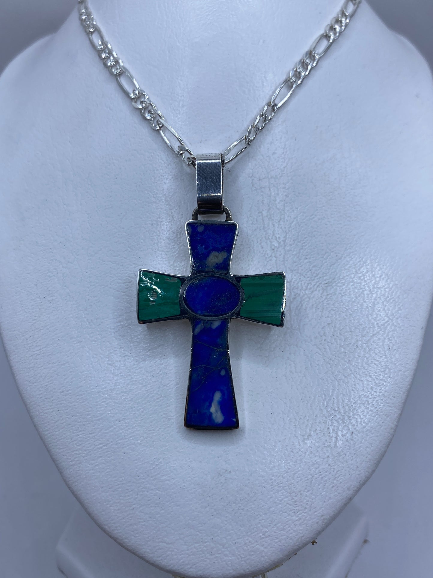 Detalle de las incrustaciones de piedra en la cruz de plata .950