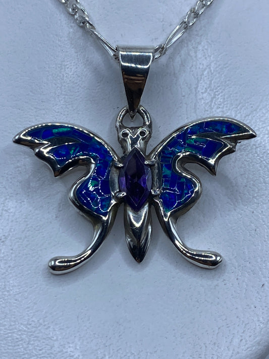 Dije de plata ópalo de fuego azul colgando de cadena plateada contra el pecho