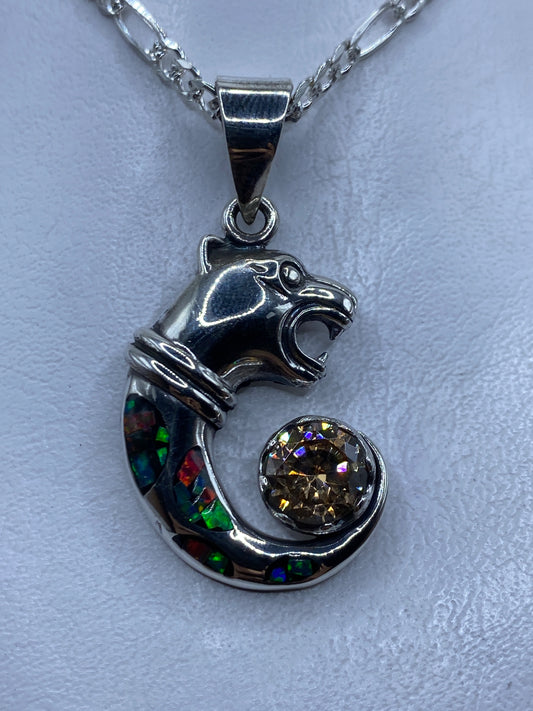 Dije de plata con caballo repujado y ópalo de fuego multicolor colgando de una cadena