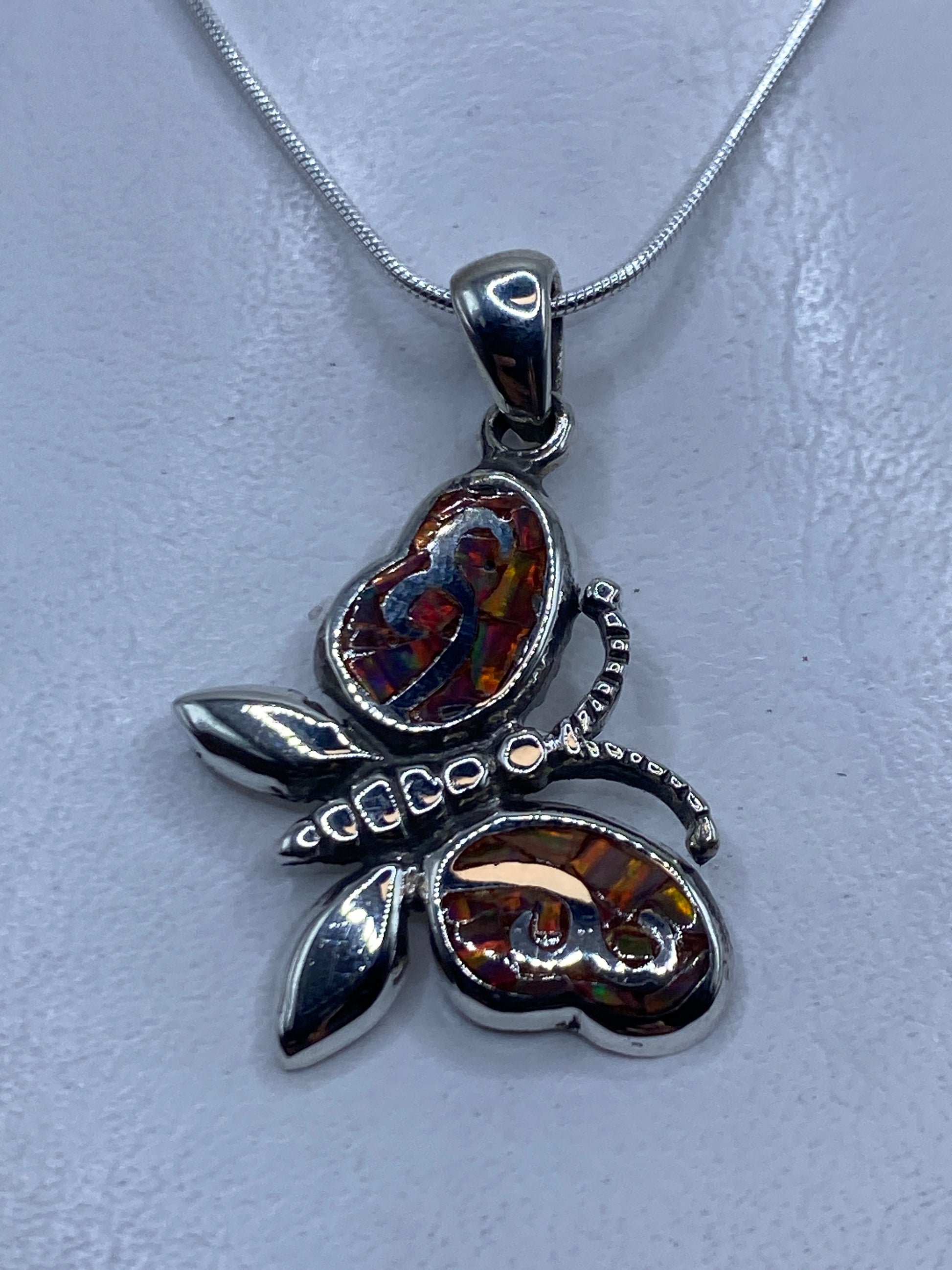 Dije de plata con ópalo de fuego multicolor en forma de maripota, incluye cadena de plata .950