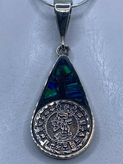 Dije de plata .950 con cruz y ópalo de fuego azul incluye cadena, colgando de un collar