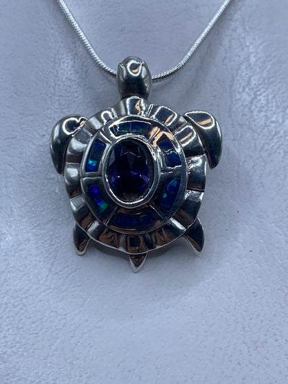 Dije de plata con ópalo de fuego azul engastado, colgando de cadena de plata