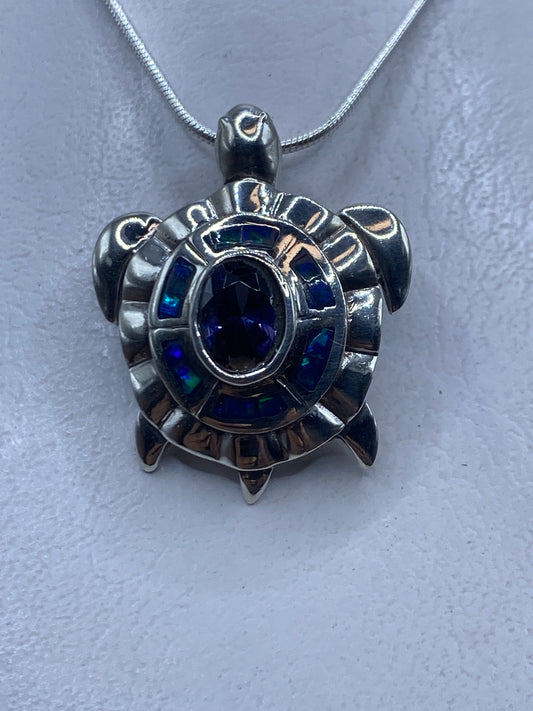 Dije de plata con ópalo de fuego azul engastado, colgando de cadena de plata