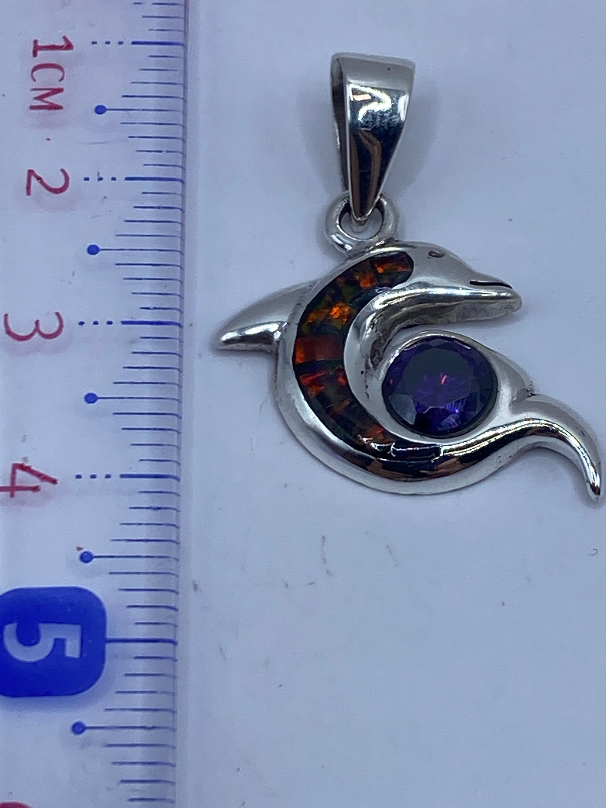 Dije delfín pesando 3.5 gramos en báscula de precisión, con el Quinto .950 visible