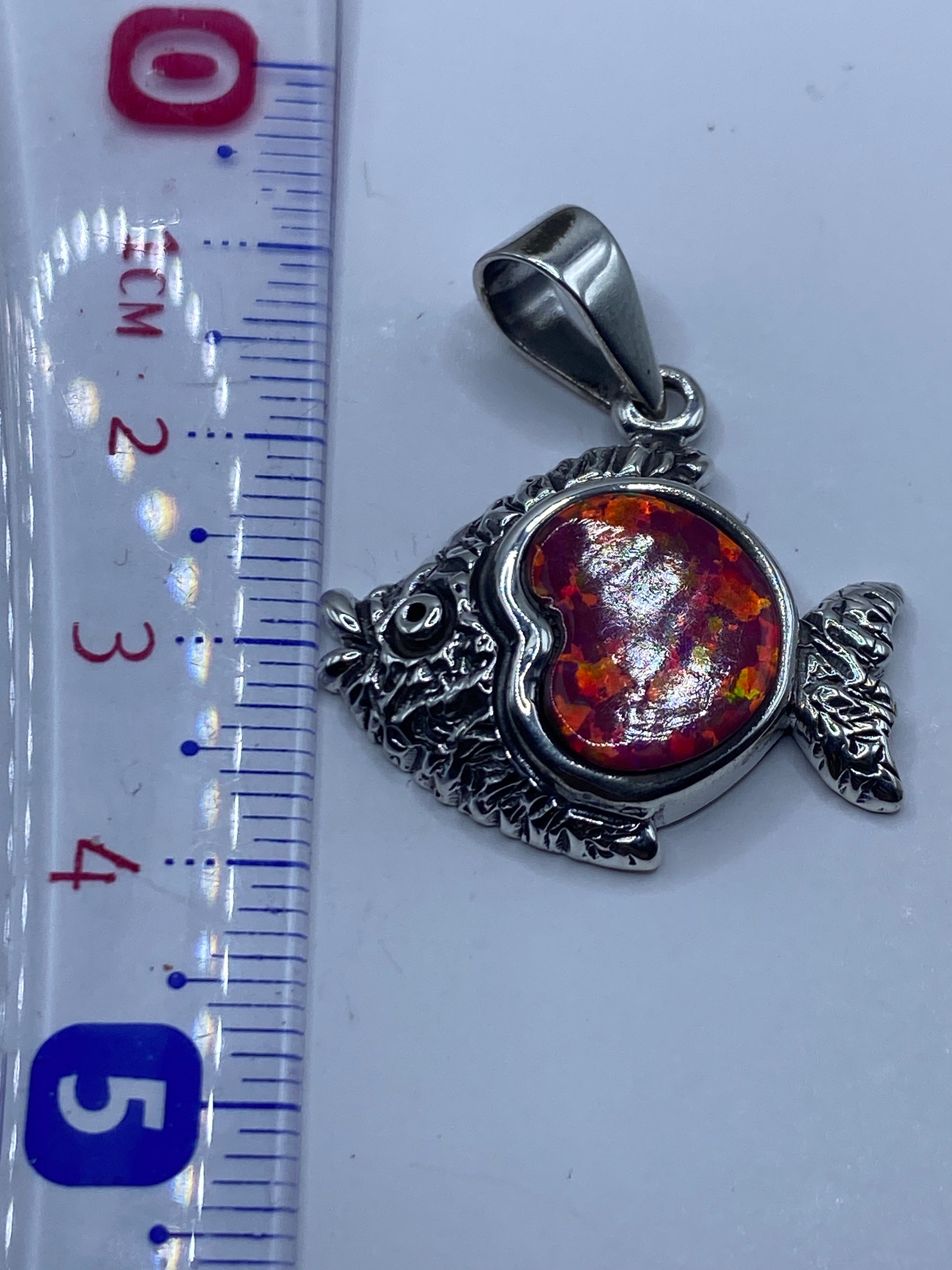Medida del dije pez de 4.1 cm sobre regla, mostrando tamaño real