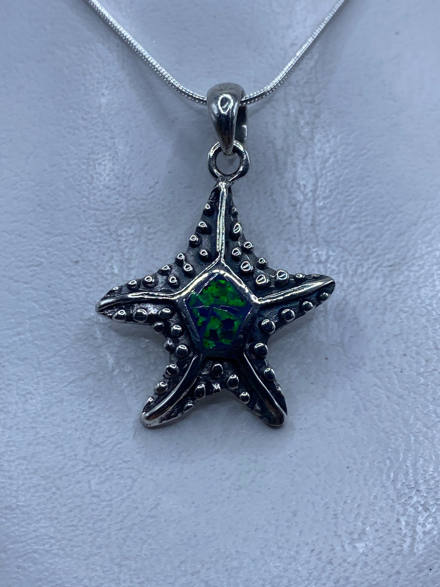 Dije de estrella de mar en plata .950 con ópalo de fuego verde engastado en el centro