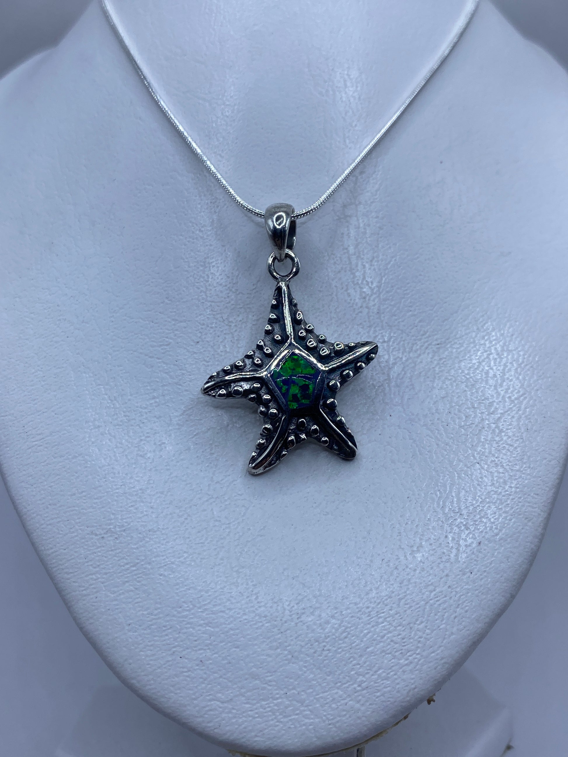 Dije colgando de cadena de plata mostrando el ópalo de fuego verde brillante