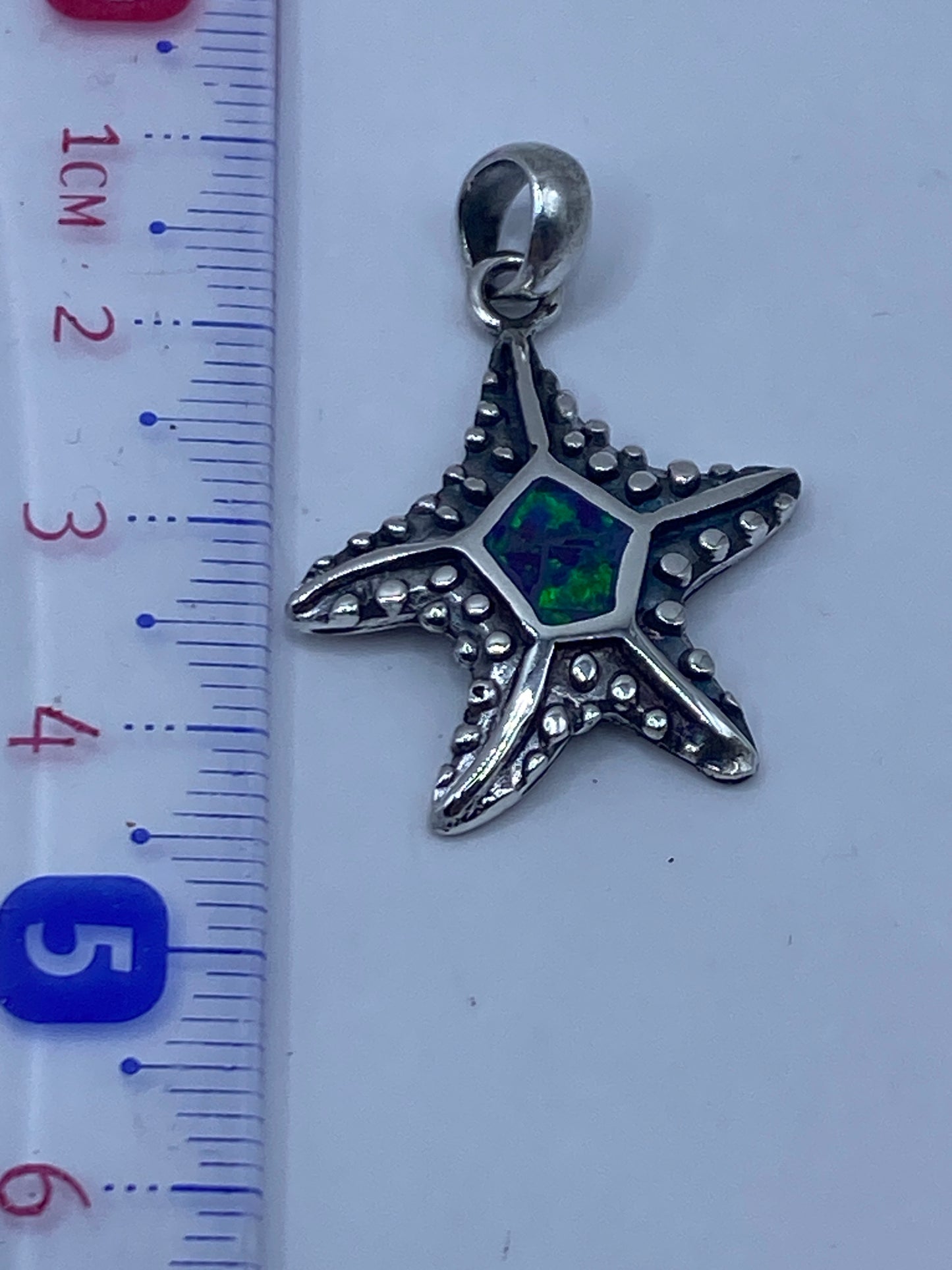 Detalle de engaste a mano del ópalo en la estrella de mar, con Quinto .950 visible