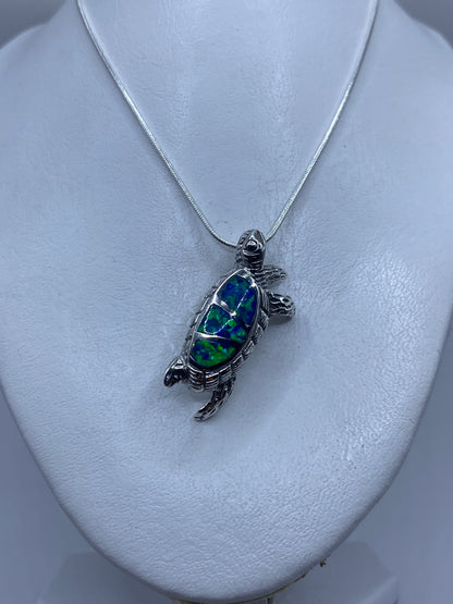 Medición del dije tortuga: 4.1 cm de largo sobre regla de centímetros