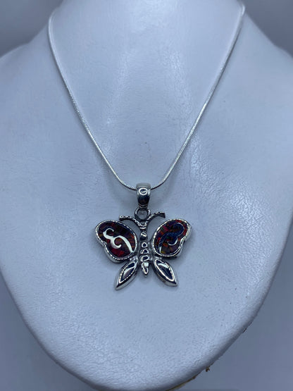 Detalle del Ópalo de Fuego multicolor en el dije mariposa de Taxco